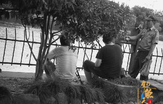 管执法队员在劝阻贴沙河边的钓鱼者