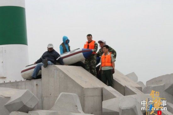 8月21日，唐山市港兴边防派出所民警正在救助被困的垂钓爱好者。