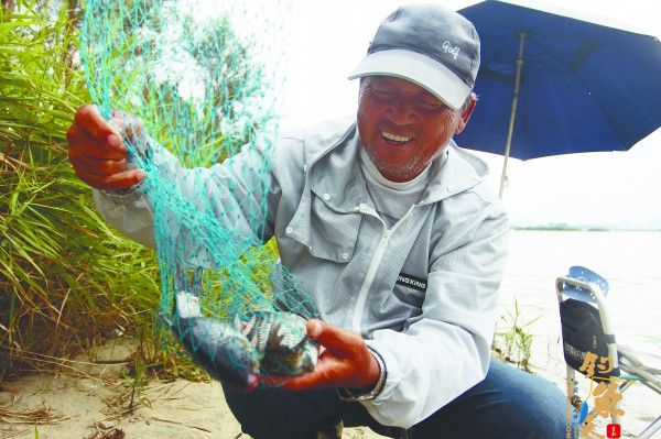 夹河红旗西路段,收获了两条大鱼的李先生高兴得合不拢嘴。