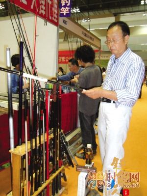 重庆国际会展中心,市民在休博会上看钓鱼竿