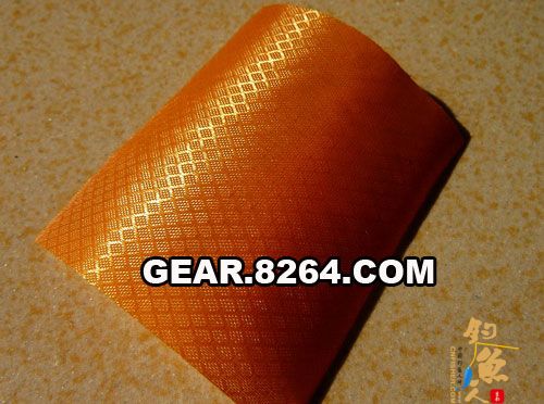 第一片布料,这是牧高笛自冲气垫的上表面,格子布的210T涤纶,手感很滑,内面压胶以密封空气。