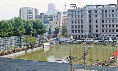 高楼大厦水泥墙围着一个钓鱼塘？