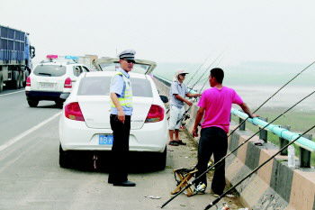 一群钓友胶州、城阳交界处的大沽河桥占道钓鱼,民警赶劝离