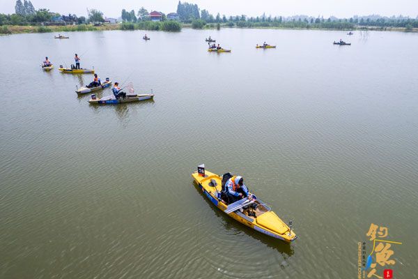  5月27日，吴晋斌（前）在比赛中测量鱼获长度（无人机照片）